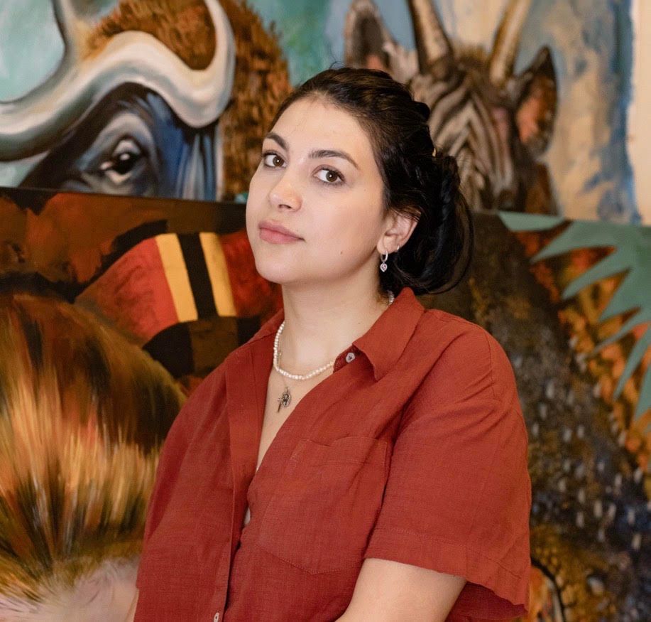Portrait of Angelika Van in front of her paintings